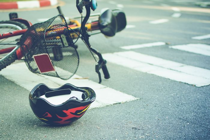 Bicycle and a helmet lying on road